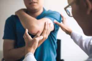 Doctor examining a patient's elbow