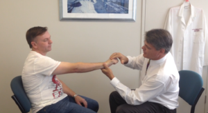 Dr Kirkham examining a patient with Tennis Elbow